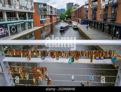 Vorhängeschlösser, die an Geländern auf der Love Lock Bridge über den Birmingham Canal Old Line von The Cube und der Mailbox in Birmingham, England, verschlossen sind. Stockfoto