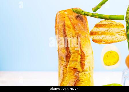 Frisches Brot, Spargel und Ei. Zum Frühstück gibt es Inridients. Gleichgewichtsschwimmende Lebensmittel. Balance Levitation Food. Gesunde Vitamin-Ernährung Stockfoto