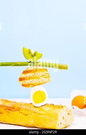 Frisches Brot, Spargel, Kiwi und Ei. Zum Frühstück gibt es Inridients. Gleichgewichtsschwimmende Lebensmittel. Balance Levitation Food Stockfoto