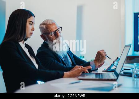 Leitender Geschäftsmann hilft jungen Kollegen Stockfoto
