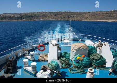 Ein Blick von der Gozo Channel Line Passagier- und Fahrzeugfähre, die die Insel Gozo verlässt. Fragment der Fähre. Grüne Seile und Bauhelme Stockfoto