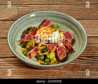 Salat mit gebratenen Thunfisch, pochiertem Ei, Avocado und Gemüse Stockfoto