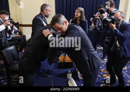 Der republikanische Repräsentant aus Illinois, Adam Kinzinger (R), begrüßt Sgt. Aquilino Gonell von der US Capitol Police, als er vor Mitgliedern des Select Committee zur Untersuchung des Angriffs auf das US Capitol am 6. Januar eintrifft, einschließlich des Vorsitzenden und demokratischen Vertreters von Mississippi Bennie Thompson, Während ihrer ersten Anhörung im Bürogebäude des Cannon House auf dem Capitol Hill in Washington, DC, USA, am 27. Juli 2021. Das Komitee wird Aussagen von Mitgliedern der US-Polizei des Kapitols und des Metropolitan Police Department hören, die versucht haben, das Kapitol vor dem Aufstand zu schützen Stockfoto