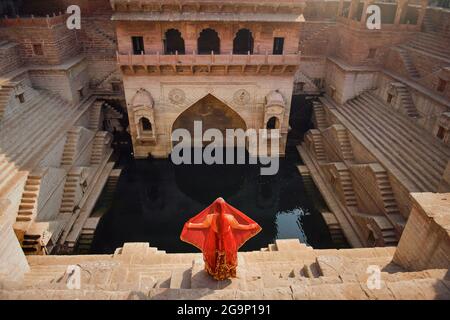 Frauen in Saris Wassertragen bei Schritt gut, Jaipur, Rajasthan, Indien Stockfoto