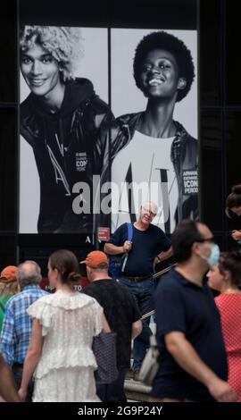 Sonntagnachmittag auf der 5th Avenue in New York City, 25/07/21. Nachdem die überfüllten Straßen New Yorks während der COVID-19-Pandemie still wurden, sind die Menschen wieder auf der Straße, viele sind ohne Maske oder Gesichtsbedeckung unterwegs. Das Foto zeigt einen Mann (in der Mitte) ohne Gesichtsbedeckung, der auf den überfüllten Stufen der St. Patrick’s Cathedral auf der 5th Avenue in Midtown Manhattan steht. Stockfoto
