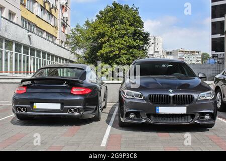 Kiew, UA - 24. August 2017: Zwei Autos: Porsche 911 Turbo und BMW 525 (f10) M Sport Paket in einer Farbe. Private Autos in der Nähe geparkt. Stockfoto