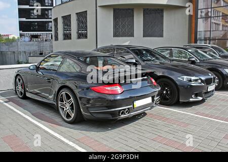 Kiew, UA - 24. August 2017: Zwei Autos: Porsche 911 Turbo und BMW 525 (f10) M Sport Paket in einer Farbe. Private Autos in der Nähe geparkt. Stockfoto