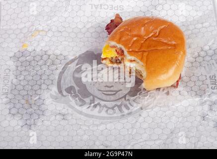 Wendy's Baconator Breakfast Sandwich auf Wrapper mit Biss Stockfoto