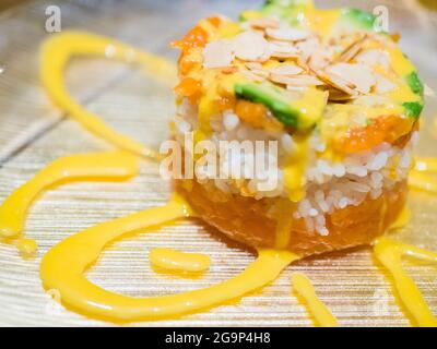 Typisch japanisches Gericht mit Sushi, Reis und Fisch, mit Sauce, Salat, Sushimi und Sesam. Japanischer Burger mit Reis, Lachs, Avocado, Mandeln und d Stockfoto