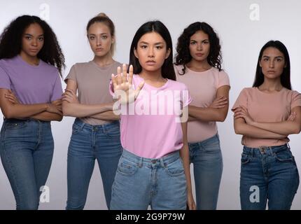 Asiatische Dame Gesturing Stop Stehen Mit Gruppe Von Frauen, Studio Stockfoto