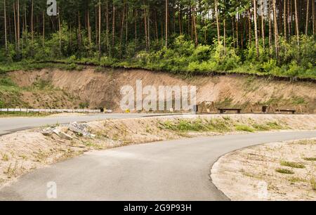 Asphaltierte Straße für das Sommertraining von Biathleten auf einem Trainingsschießstand in der Mitte des Waldes, mit Zielen und Zielen, im Freien, Altai Stockfoto