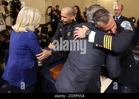 Von links begrüßt die US-Vertreterin Liz Cheney (Republikaner von Wyoming) Sgt. Aquilino Gonell als US-Repräsentant Adam Kinzinger (Republikaner von Illinois) begrüßt Michael Fanone, die US-Polizei des Kapitols, während sie vor dem House Select Committee, das den Angriff auf das US-Kapitol vom 6. Januar am 27. Juli 2021 im Cannon House Office Building in Washington, DC, untersucht, ein Zeugnis ablegt.Quelle: Oliver Contreras/Pool über CNP /MediaPunch Stockfoto