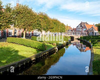 Häuser mit Gärten am Wasser am Kanal Eegracht in der Stadt IJlst, Friesland, Niederlande Stockfoto