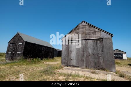 Schwarz lackierte Fischerhütten aus Holz in den Sanddünen von Winterton on Sea in der Nähe von Great Yarmouth an der Ostküste von Norfolk UK. Stockfoto