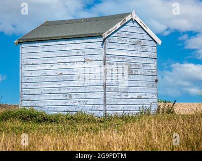 Landschaft einer hellblauen, verwitterten Strandhütte aus Holz mit abblätternder Farbe am Meer, aufgenommen in Greatstone New Romney Kent England am 17th. Juli 2021 Stockfoto