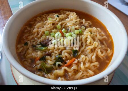 Eine Schüssel koreanische udon-Nudeln mit würziger Suppe, serviert in einer Schüssel. Stockfoto