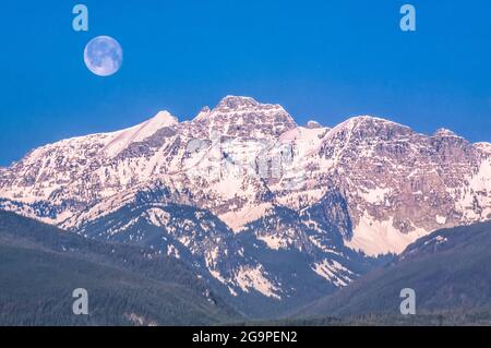 Der Mond über den Gipfeln der Mission liegt oberhalb des Elch-Creek-Tals in der Nähe von condon, montana Stockfoto