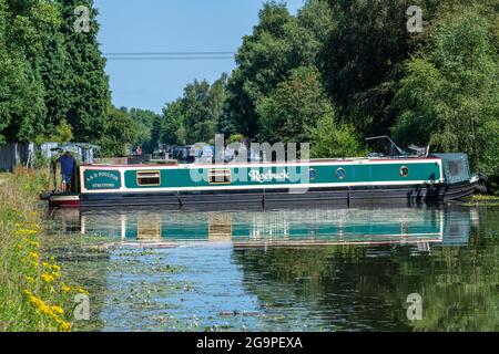 Mann, der am Steuer eines traditionellen Schmalboots oder Barges auf dem bridgewater-Kanal im Verkauf, Greater manchester, großbritannien, steuert Stockfoto