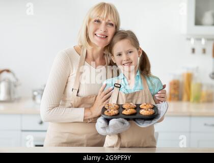 Glückliche ältere Frau und ihre Enkelin bereiten Kekse vor Stockfoto