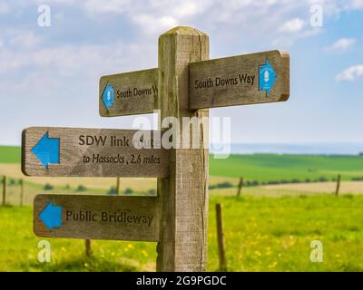 Ein Wegweiser auf dem South Downs Way in der Nähe von Clayton Windmills in Sussex, Großbritannien, der Anweisungen für mehrere Routen zeigt. Stockfoto