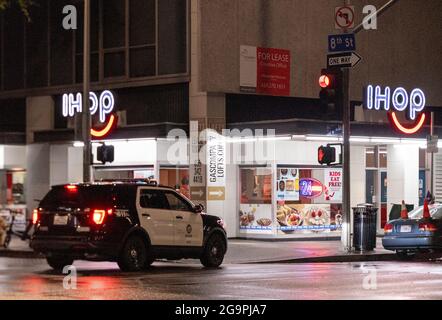 Polizeiauto parkte in der Nähe des IHOP Restaurants, nachts beleuchtet, Ecke 8th Street & Flower str, Downtown Los Angeles, California, USA Stockfoto