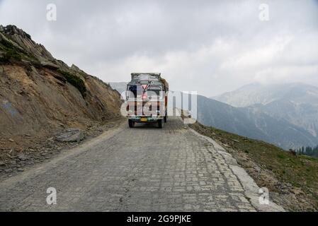 Ein Lastwagen wurde auf dem Razdan Top im Gurez Valley bewegt. Gurez liegt entlang der LOC (Line of Control) im nördlichen Teil Kaschmirs. Das Gurez-Tal war der Schlüssel zur Seidenstraße von Europa nach Kashgar in China und Heimat des shinasprachigen Dard-Stammes, aber es war erst 2007 für die Welt geöffnet. Vor 2007 war Gurez nur während der Kolonialzeit geöffnet, als Reisende das Tal erkunden kamen. Die Kontrolllinie schneidet nun durch das idyllische Tal und trennt die Dards von ihren indo-arischen Brüdern in Gilgit, Chilas und Astore, die in Pakistan liegen. Stockfoto