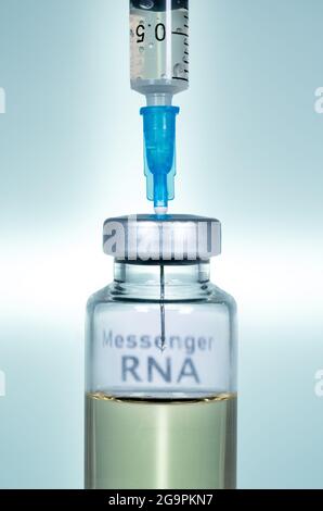 Makro einer hypodermischen Spritze oder Nadel, die mit mRNA-Impfstoff aus der Flasche vor blauem Hintergrund gefüllt wird Stockfoto