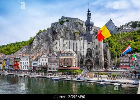 Die historische Stadt Dinant mit der belgischen Flagge und der Zitadelle auf dem Felsen und der Stiftskirche Notre-Dame an der Maas, Wallonien, Belg Stockfoto