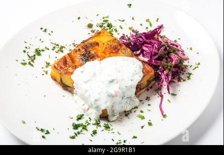 Stück Fleischkuchen mit Gemüse und einer Garnierung von Rotkohl auf einem weißen Teller. Nahaufnahme Stockfoto