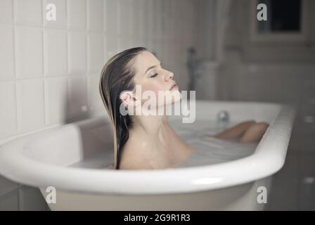 Schöne Frau in einer Vintage-Badewanne Stockfoto