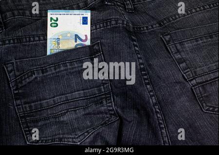 20 Euro, die aus der Tasche schwarzer Jeans kommen Stockfoto