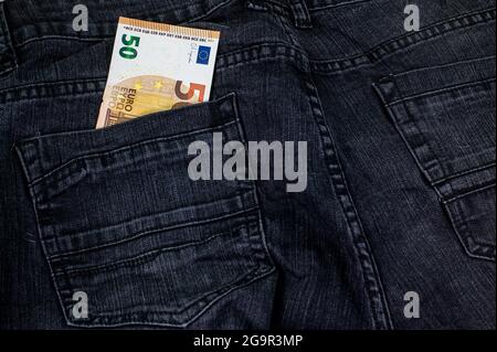 50 Euro, die aus der Tasche schwarzer Jeans kommen Stockfoto