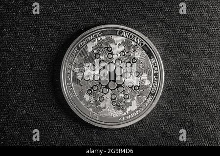 Cardano-Münze mit Logo in schwarz-weiß mit dunklem Hintergrund. Cardano ist eine Krypto-Münze, die auf ethereum tec basiert und die beliebteste in der Blockchain ist Stockfoto