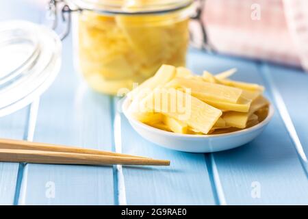 In Scheiben geschnittene Bambusdosensprossen in einer Schüssel auf einem blauen Tisch. Stockfoto