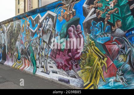 Farbenfrohe, helle Graffiti an der Berliner Mauer auf der Ostseite. Die größte Open-Air-Kunstgalerie der Welt. Deutschland, München - 28. April 2011 Stockfoto