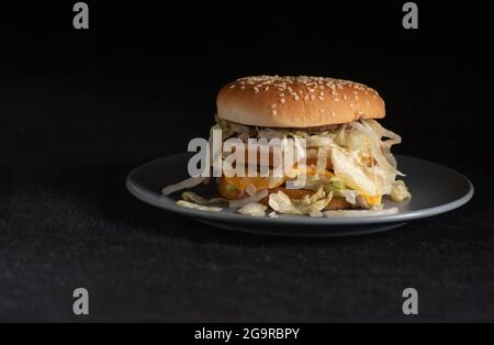 McDonalds Big Mac Hamburger auf einer grauen Untertasse auf dunklem Hintergrund überzogen Stockfoto