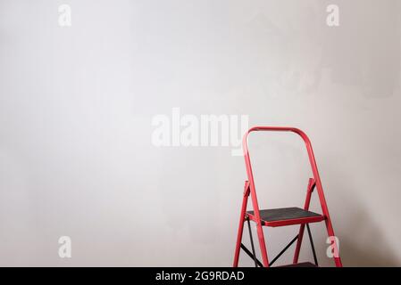 Rote Bauleiter in der Nähe von grauen Wand Hintergrund mit Kopierer Platz in neuen Zuhause Stockfoto