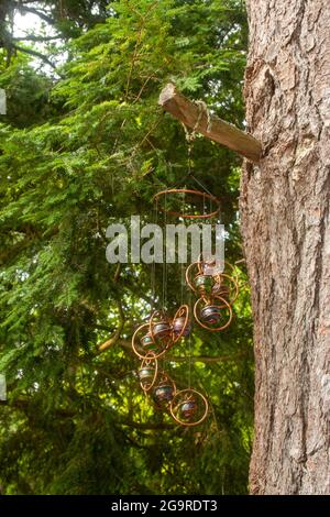 An einem Baum in Muskoka, Ontario, hängen künstlerische Windspiele Stockfoto