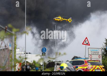 Leverkusen, Deutschland. Juli 2021. Am 27. Juli 2021 steigt Rauch von der Explosionsstelle im Chempark Leverkusen in Leverkusen auf. Mindestens eine Person sei gestorben, 16 seien verletzt worden und vier seien nach einer Explosion am Dienstag im Chempark Leverkusen, einem Industriepark für Chemieunternehmen in Deutschland, noch vermisst worden, sagte Currenta, das Unternehmen, das den Park betreibt. Quelle: Tim Oelbermann/Xinhua/Alamy Live News Stockfoto