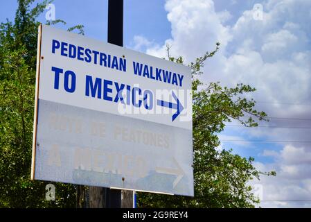 Nahaufnahme eines weißen Schildes mit blauem Pfeil und Schriftzug mit der Aufschrift „Fußgängerweg nach Mexiko“ an der Grenze zwischen den USA und Mexiko in Douglas, AZ Stockfoto