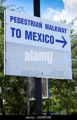 Auf einem weißen Schild mit blauer Beschriftung und Pfeil steht „Fußgängerweg nach Mexiko“ an der Grenze zwischen den USA und Mexiko in Douglas, AZ Stockfoto