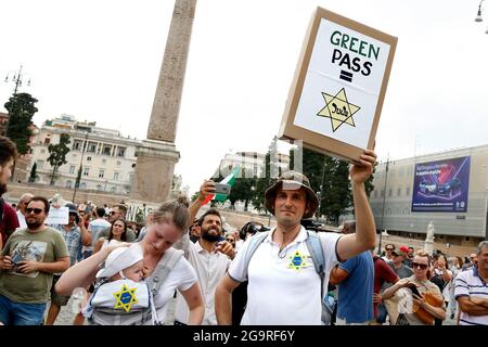 Rom, Italien. Juli 2021. Ein Mann mit seiner Frau und seinem Kind, zeigt ein Banner, das symbolisiert, dass der Grüne Pass wie der David-Stern ist, der auf die Kleidung der juden in nazi-Faschismus-Zeiten genäht wurde, während der Demonstration gegen den Grünen Pass, Das bescheinigt die Impfung gegen covid 19, nach dem letzten Dekret des ministerrats, notwendig, um öffentliche Plätze wie Büros, Schulen, aber auch Restaurants zu betreten.Rom (Italien), 27. Juli 2021 Foto Samantha Zucchi Insidefoto Kredit: Insidefoto srl/Alamy Live News Stockfoto