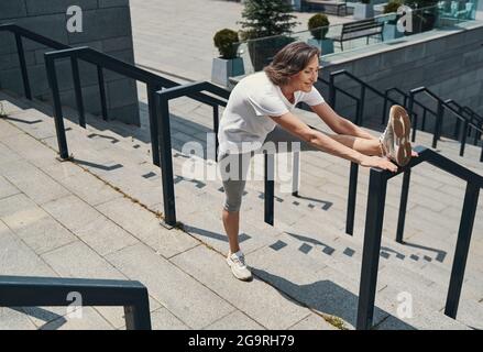 Glücklich reifen weiblichen tun Übungen an Treppen im Freien Stockfoto