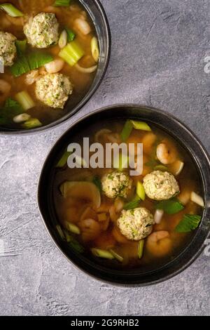 Suppe mit Garnelen, Hühnerfleischbällchen, Frühlingszwiebeln und Reis Stockfoto