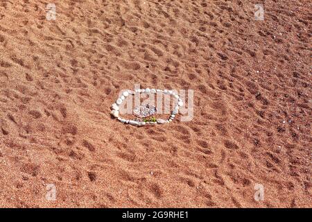 Red Sand Beach Hintergrund . Steine Zusammensetzung am Strand, Urlaubskonzept Stockfoto