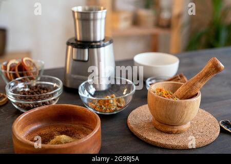 Gruppe von Schalen in verschiedenen Größen mit ätherischen Ölen, Kaffeebohnen, trockenen Blumen und anderen Zutaten für die Herstellung von Naturkosmetikprodukten Stockfoto