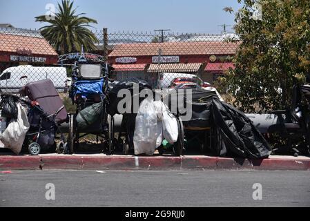 Los Angeles, CA USA - 30. Juni 2021: Obdachlose in Los Angeles stehen auf dem Bürgersteig Possionen und Rollstühle Stockfoto