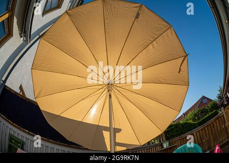 Die Sonne scheint durch einen großen Sonnenschirm Stockfoto