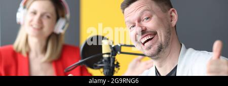 Fröhlicher Mann und Frau arbeiten an der Luft des Radios Station Stockfoto