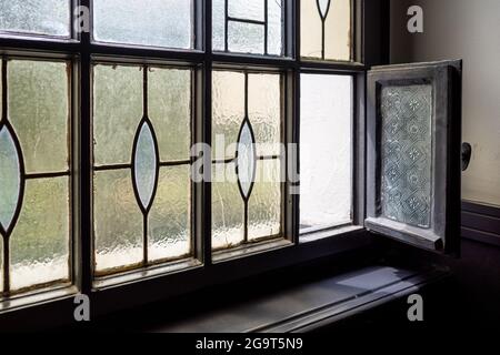Selektiver Fokus auf teilweise öffnende alte klassische Vintage-Fenster im Treppenhaus. Stockfoto